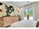 Well-lit bedroom featuring a dresser, vibrant artwork, and French doors that lead outside at 129 Old Norton Rd, Fayetteville, GA 30215