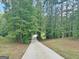 Long concrete driveway winds through a serene forest, creating a peaceful approach to the property at 129 Old Norton Rd, Fayetteville, GA 30215
