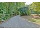 Gravel driveway leads to the property surrounded by mature trees and lush greenery at 129 Old Norton Rd, Fayetteville, GA 30215