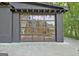 Modern barn-style home with glass garage door, black exterior, and concrete patio at 129 Old Norton Rd, Fayetteville, GA 30215
