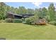 Home exterior featuring a deck, dark gray siding, and lush green landscaping at 129 Old Norton Rd, Fayetteville, GA 30215