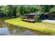 Waterfront view of a modern home featuring a wooden deck, patio, and manicured lawn at 129 Old Norton Rd, Fayetteville, GA 30215