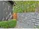 View of the backyard with stone wall, wood gate, shrubbery, and mature trees at 129 Old Norton Rd, Fayetteville, GA 30215