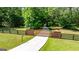 Private gated entrance with black fencing and a smooth concrete drive, surrounded by mature trees and green lawn at 129 Old Norton Rd, Fayetteville, GA 30215