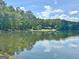 Scenic lake view showcasing the home nestled among trees, with clear reflections on the water's surface at 129 Old Norton Rd, Fayetteville, GA 30215