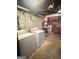 Functional laundry room with washer, dryer, concrete walls, and exposed plumbing at 2574 Rosedale Dr, Morrow, GA 30260