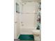 Clean white bathroom with a shower-tub combination, decorative shower curtain, and teal rug at 710 Bluebird Se Dr, Conyers, GA 30094
