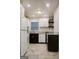 Modern kitchen featuring granite countertops, stainless steel sink, and white and black cabinets at 710 Bluebird Se Dr, Conyers, GA 30094