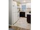 Bright kitchen with white appliances, dark cabinets, and granite countertops against hexagon tile floors at 710 Bluebird Se Dr, Conyers, GA 30094