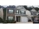 Charming two-story home featuring a combination of brick and siding exterior, a well-maintained lawn, and a one car garage at 9487 Lakeview Rd, Union City, GA 30291