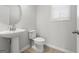 Powder room with pedestal sink, elongated toilet, brushed nickel hardware, and natural light at 77 Werner Brook Way Sw, Atlanta, GA 30354