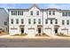 Charming townhomes featuring white siding, black shutters, and attached garages, with sidewalks and well-maintained landscaping at 77 Werner Brook Way Sw, Atlanta, GA 30354