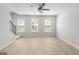 Spacious living room featuring three windows, a ceiling fan, and carpeted stairs at 77 Werner Brook Way Sw, Atlanta, GA 30354