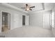 Main bedroom with ceiling fan, neutral carpet, a large window, and doors leading to bathroom at 77 Werner Brook Way Sw, Atlanta, GA 30354