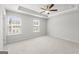 Large main bedroom features two windows with blinds, tray ceiling, and ceiling fan at 77 Werner Brook Way Sw, Atlanta, GA 30354