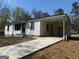 A well-maintained home featuring a convenient covered parking area and clean white siding at 6006 Blackhawk Se Trl, Mableton, GA 30126