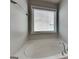 Corner soaking tub featuring chrome fixtures and a window with a view of the property at 3741 Upland Dr, Mcdonough, GA 30253