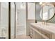 Bright bathroom featuring a skylight, round mirror, modern vanity, and tub with shower at 104 Pine Pt, Peachtree City, GA 30269