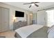 Inviting bedroom with ceiling fan, dresser, mounted TV, and sliding barn door to bath at 104 Pine Pt, Peachtree City, GA 30269