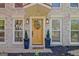 Close-up of the home's front door with decorative wreath, lighting and small shrubs at 104 Pine Pt, Peachtree City, GA 30269