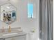 Bright bathroom features a gray vanity, marble countertop, gold fixtures, and a decorative mirror and window at 265 High St, Fayetteville, GA 30214