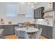 Open kitchen with gray cabinets, stainless steel appliances, and a round dining table with chairs at 265 High St, Fayetteville, GA 30214