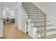 Bright view of stairs with hardwood floors and modern black railings with a storage area under the stairs at 265 High St, Fayetteville, GA 30214
