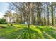 Spacious backyard features a shed and lush green grass with scattered flowers beneath mature trees at 3685 Concordia Rd, Decatur, GA 30034