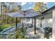 Back patio area with outdoor seating under a shade umbrella and a grill at 3685 Concordia Rd, Decatur, GA 30034
