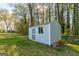 Backyard shed with a window and door on the side of the house in a grassy yard at 3685 Concordia Rd, Decatur, GA 30034