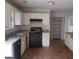 Functional kitchen with white cabinets, black appliances, and a large window for natural light at 50 Village Walk, Covington, GA 30016