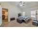 Bedroom with ensuite featuring a ceiling fan, two windows, and carpeted floor at 4050 Villagewood Ln, Ellenwood, GA 30294