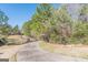 Paved driveway entrance to property with surrounding trees and landscaping at 4050 Villagewood Ln, Ellenwood, GA 30294