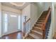 Bright foyer featuring hardwood floors, a coat rack, and a carpeted staircase at 4050 Villagewood Ln, Ellenwood, GA 30294