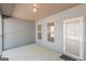 Covered porch with gray siding, concrete floor, two windows and access door at 4050 Villagewood Ln, Ellenwood, GA 30294