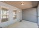 Covered porch with gray siding, concrete floor, two windows and access door at 4050 Villagewood Ln, Ellenwood, GA 30294