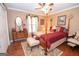 Charming bedroom features a four-poster bed, hardwood floors, and sunny windows at 245 Jewel Blf, Fayetteville, GA 30214