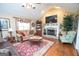 Cozy living room features a fireplace, hardwood floors, and a large window with decorative curtains at 245 Jewel Blf, Fayetteville, GA 30214