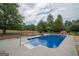 A sparkling in-ground pool with a concrete deck, surrounded by lush greenery and inviting lounge chairs at 245 Jewel Blf, Fayetteville, GA 30214