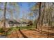 Wide backyard with mature trees, a storage shed, and spring flowers at 65 Dundee Pl, Sharpsburg, GA 30277