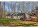 Wide shot of the backyard featuring a large deck, mature trees, and a well-maintained lawn at 65 Dundee Pl, Sharpsburg, GA 30277