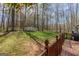 View of the large, wooded backyard and storage shed from the spacious wooden deck at 65 Dundee Pl, Sharpsburg, GA 30277