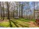 Lush, wooded backyard with tall trees and storage shed providing privacy and tranquility at 65 Dundee Pl, Sharpsburg, GA 30277