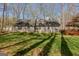 Back view of home, showcasing the large, lush backyard with a deck and mature trees at 65 Dundee Pl, Sharpsburg, GA 30277