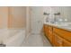 A clean bathroom featuring double sinks, a bathtub, and tile floors at 65 Dundee Pl, Sharpsburg, GA 30277