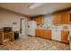 Functional kitchen featuring brick-look tile flooring, wooden cabinets and white appliances at 65 Dundee Pl, Sharpsburg, GA 30277