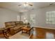 Inviting living room featuring a ceiling fan, wood floors, and comfortable seating at 65 Dundee Pl, Sharpsburg, GA 30277