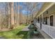 Charming covered porch with verdant plants and shrubbery adds elegance and curb appeal to the house at 65 Dundee Pl, Sharpsburg, GA 30277