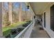 Relaxing covered porch with plants and seating, providing a tranquil outdoor space with wooded views at 65 Dundee Pl, Sharpsburg, GA 30277