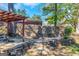Stone retaining wall with water feature and pergola in a shaded backyard at 111 Highway 138 E, Stockbridge, GA 30281